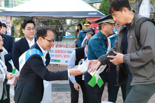 여영현(왼쪽) 농협 상호금융대표가 서울 서대문역 인근에서 류재혁 남대문경찰서장과 함께 보이스피싱 피해 예방 캠페인을 펼치고 있다.  <농협중앙회 제공>